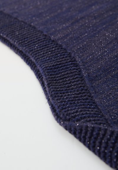 Tuvplāksne ar tumši zilu adītu audumu ar ribotu apmali un diskrētu metāliski spīdīgu pavedienu, kas ievīts visā audumā.