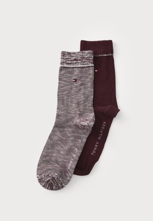 Two pairs of socks: one is maroon, the other has a gray striped pattern. Both feature the Tommy Hilfiger logo near the cuff.