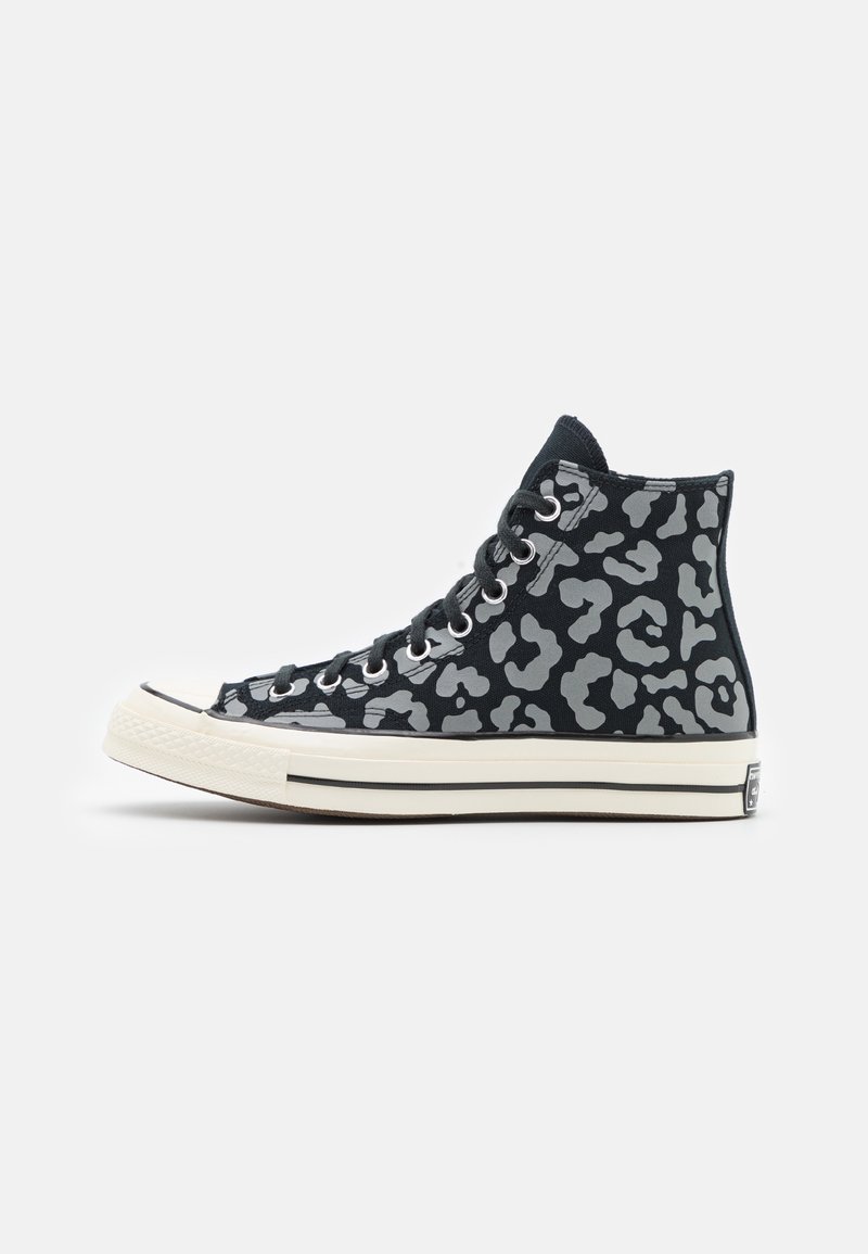 Baskets montantes noires avec imprimé léopard gris, semelle en caoutchouc blanche et lacets noirs, vues de profil extérieur sur fond blanc.