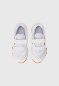 Baskets blanches pour enfants avec double bande velcro et semelles en caoutchouc orange, vues de dessus sur un fond blanc.