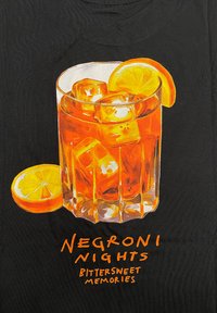 Glass of orange-colored beverage with ice cubes, garnished with a lemon slice, on a black background. Text: "Negroni Nights Bittersweet Memories."