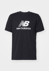 Camiseta de algodón negra con cuello redondo y mangas cortas. Presenta un logotipo en blanco "NB" y el texto "new balance" en la parte delantera.