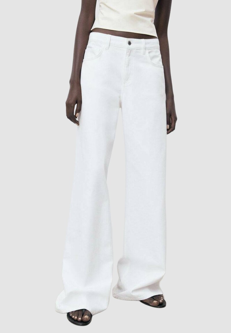 Wide-leg white jeans made of denim, featuring a high waist and front pockets, with a clean design and no visible embellishments.