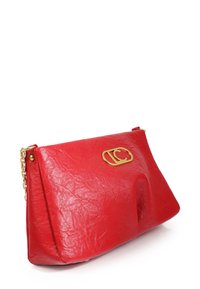 Rode leren clutch met een gestructureerde maar zachte rechthoekige vorm, afgewerkt met een geborsteld oppervlak, en voorzien van een goudkleurig logo en kettinghengsel.