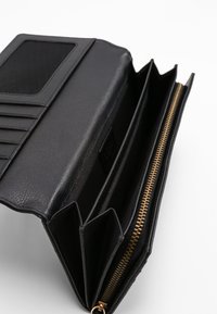 Schwarze Lederbörse mit strukturierter Oberfläche, ausgestattet mit mehreren Kartenfächern, einem Reißverschlussfach und einem ID-Fenster aus Netzmaterial. Goldfarbene Reißverschlussdetails.