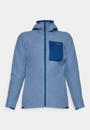 Modrá fleecová bunda s textúrovaným vzorom, predným zipsom, kapucňou a kontrastnou modrou náprsníkou. Obsahuje logo Patagonia.