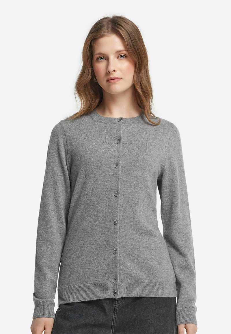 Grå cardigan i mjukt stickat material, med rund hals, knappstängning fram och långa ärmar med ribbade mudd och fåll.