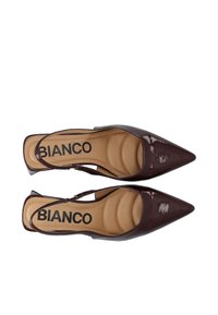 Burgundy lakattu nahkainen slingback-korkokenkä, jossa on teräväkärkinen muoto, pehmustettu pohja ja brändätty sisäpohja, suunniteltu tarjoamaan turvallinen istuvuus.
