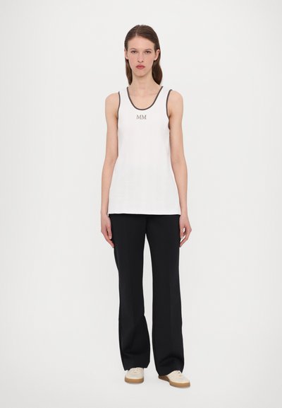 White tank top with textured fabric, features gray trim and embroidered "MM" logo. Paired with black wide-leg pants and beige shoes.