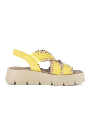 Sandale à plateforme en daim jaune avec une semelle épaisse beige, des lanières larges croisées cousues et une bride arrière avec un insert élastique.