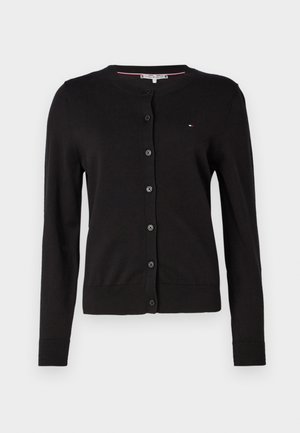 Cardigan nero realizzato in morbido tessuto a maglia, dotato di scollatura rotonda, bottoni frontali e polsini e orlo a costine. Piccolo logo sul petto.