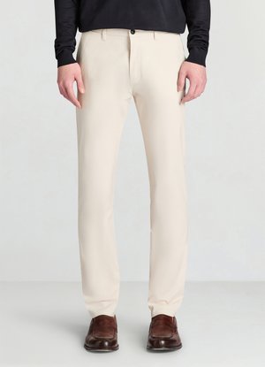 Pantaloni beige con design a gamba dritta e texture liscia, dotati di chiusura con bottone e tasche frontali, abbinati a mocassini marroni.