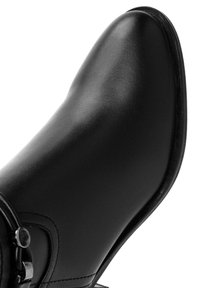 Black ankle boot featuring smooth leather material, pointed toe design, and a decorative metal buckle accent on the side.