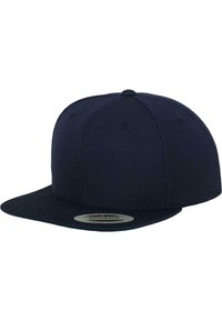 Marinblå snapbackkeps i texturerat tyg, med en plan skärm, justerbar baksida och en cirkulär logotyp-patch på framsidan.