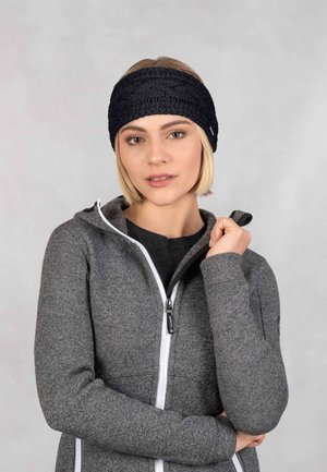 Zwarte gebreide hoofdband met een gestructureerd, geweven ontwerp. Gecombineerd met een grijze zip-up jack met witte accenten en een aansluitende snit.