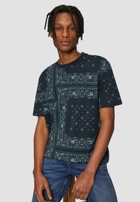 Korte mouw navy t-shirt met een bandana printontwerp, ingewikkelde patronen en een ontspannen pasvorm. De stof lijkt glad met een zachte textuur.