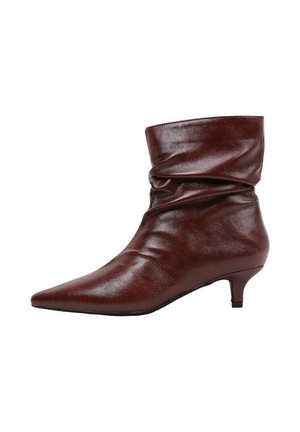 Bottine à enfiler en cuir marron avec un bout pointu et un petit talon kitten, présentée sur un fond blanc.