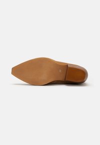 Semelle de chaussure en suède beige avec une forme pointue. Présente un talon en caoutchouc texturé de couleur brun clair et un marquage de taille 37. Fini lisse dans l'ensemble.