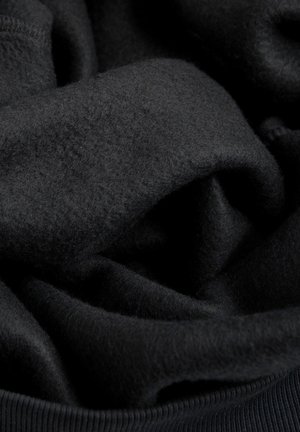 Zwart fleece stof met een zachte, gestructureerde oppervlakte, voorzien van gevouwen lagen en een geribbeld rand, wat een gezellige uitstraling creëert.