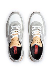 Białe i szare buty sportowe posiadają design z zamszu i siateczki, z perforowanymi akcentami oraz czarną wkładką, sznurowanym zapięciem i gumową podeszwą.