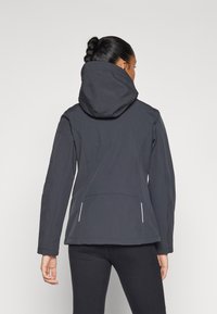 Black waterproof jacket with a hood, featuring a fitted design, textured fabric, and white accents on the pockets and hem.