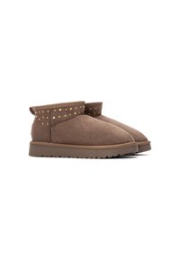 Botines de ante marrón con puntera redondeada, que cuentan con una banda con tachuelas alrededor del tobillo y una suela de goma para mayor tracción.