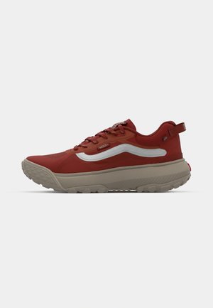 Red athletic shoes with a textured upper, a thick beige sole, and a reflective stripe. Features laces and a small heel tab.