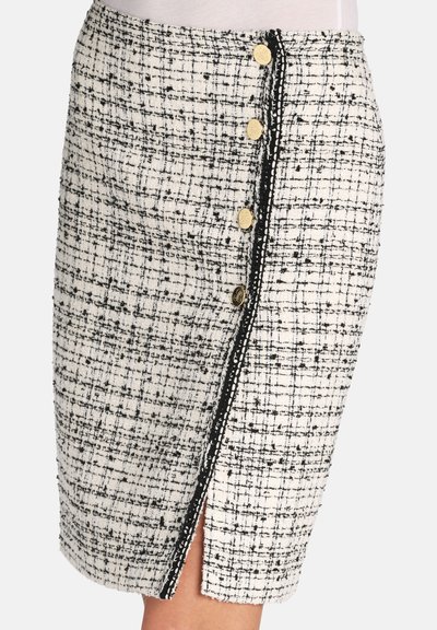 Tweednederdel i creme og sort med et struktureret mønster, med guldknapper langs siden og en slids for bevægelsesfrihed.