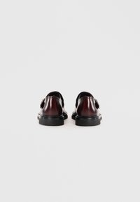 Dark burgundy leather shoes with a smooth finish, rounded toe, and black rubber sole. Features a decorative hardware accent.