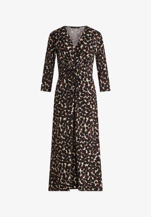 Šaty s dlouhým rukávem v hnědé a černé tečkované barvě, s výstřihem do V a stáhnutým uzlem v pase, splývající k dlouhému lemu.