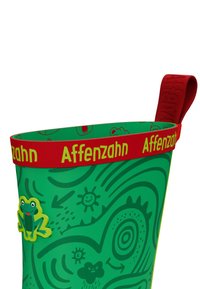 Stivale da pioggia verde con motivi astratti verde scuro, una piccola illustrazione di una rana e un polsino rosso etichettato "Affenzahn" con un anello rosso sulla parte superiore.