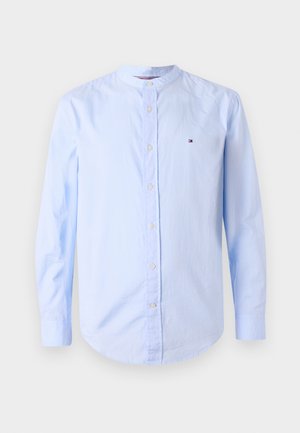 Φωτεινό γαλάζιο πουκάμισο με μακριά μανίκια, κουμπιά, γιακά μανταρίνι και μικρό κεντητό λογότυπο στο στήθος.