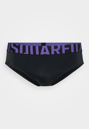 Schwarze Schwimmunterhose mit einem breiten lila Bund, der große schwarze Blockbuchstaben zeigt, präsentiert vor einem schlichten weißen Hintergrund.