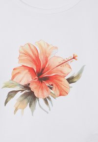 T-shirt in tessuto bianco con un'illustrazione vibrante e dettagliata di un fiore di ibisco in tonalità di arancione e rosso, con foglie verdi.
