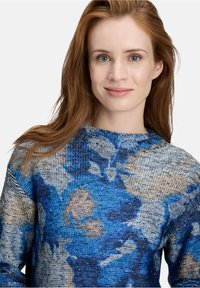 Blau- und graumusterter Strickpullover mit einer strukturierten Webart, der einen Rundhalsausschnitt und leichte Glitzereffekte im gesamten Design aufweist.