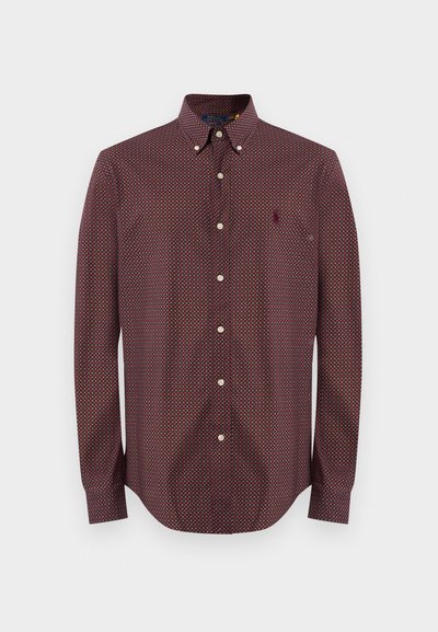 Rdeča srajca z dolgimi rokavi in geometrijskim vzorcem, kontrastnim ovratnikom in stikom s prišitim logotipom na prsih. Tkanina iz mešanice bombaža.