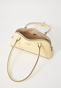 Żółta torebka z gładkiej skóry o usztywnionym kształcie, wyposażona w zamek błyskawiczny, dwa uchwyty oraz kontrastową czarną lamówkę.