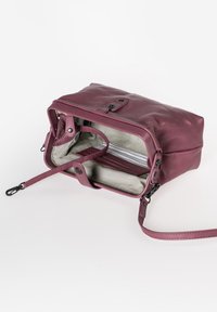 Borsa a tracolla in pelle di un profondo bordeaux, con un esterno texturizzato, chiusura con zip e fodera interna a righe con tracolla rimovibile.