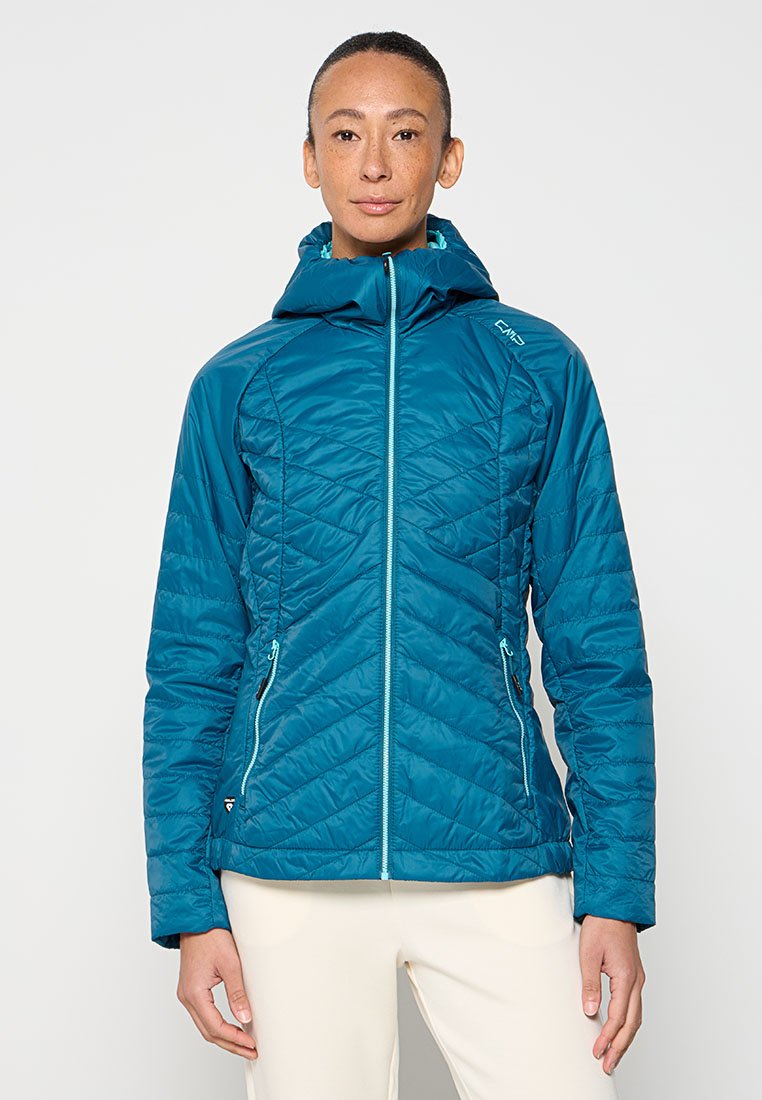 Giacca isolante color turchese con cappuccio, caratterizzata da un design trapuntato, zip frontale e due tasche laterali. Realizzata in materiale leggero e morbido.