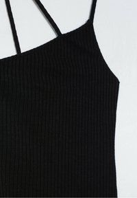 Débardeur noir côtelé avec fines bretelles texturées. Présente une silhouette ajustée et un décolleté asymétrique pour un design moderne.