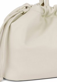 Bolso de mano de cuero crema con un diseño de parte superior fruncido, textura suave y costuras acentuadas, que presenta cierres de cuerda y una forma redondeada.