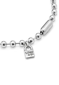 Bracelet en perles argentées avec des finitions polies et mates, comportant un charme ovale en forme de cadenas gravé "UNO de 50."