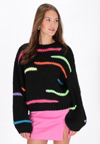 Czarny sweter dzianinowy z wielokolorowymi, falistymi paskami w neonowym różu, zieleni, pomarańczy i niebieskim; luźny krój i ściągacze na rękawach.