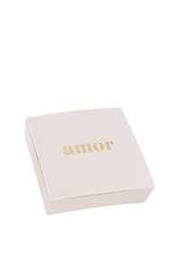 Scatola quadrata, morbida di colore rosa con una superficie liscia. La parola "amor" è impressa in caratteri dorati in grassetto sul coperchio.