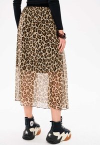 Luipaardprint, sheer maxi rok met een gathered tailleband, gecombineerd met zwarte high-top sneakers met een sterdesign en een gestructureerde zool.
