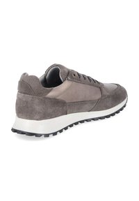 Baskets grises en daim et cuir avec lacets noirs et semelle blanche épaisse, vues en angle arrière sur fond blanc.