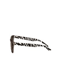 Gafas de sol negras con brazos texturizados de estampado de cebra, que presentan un diseño de marco redondeado. Las lentes son oscuras y ligeramente tintadas.