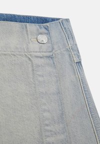 Șorturi din denim de culoare albastru deschis, cu un nasture argintiu la talie, având un design clasic cu cinci buzunare și detalii de cusătură subtile.
