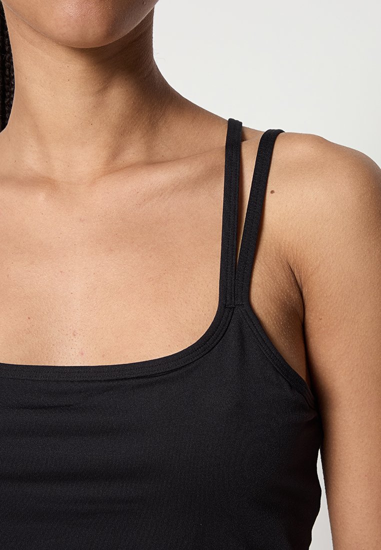 Schwarzes Trägershirt mit schmalen Trägern, quadratischem Ausschnitt, weichem Material und minimalistischem Design. Geeignet zum Layering oder für den lässigen Alltag.