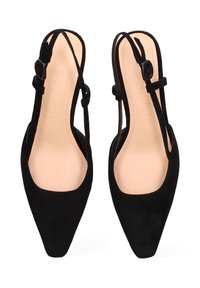 Zwarte leren puntige slingback flats met dunne verstelbare bandjes en beige binnenzolen, vanuit bovenaf weergegeven op een witte achtergrond.